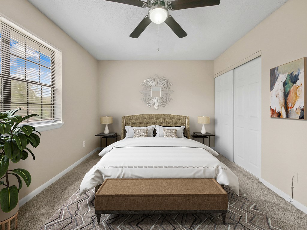 a bedroom with a large bed and a ceiling fan