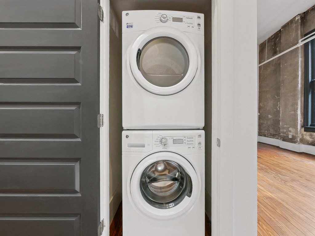 a front loading washer and dryer in a room with a door