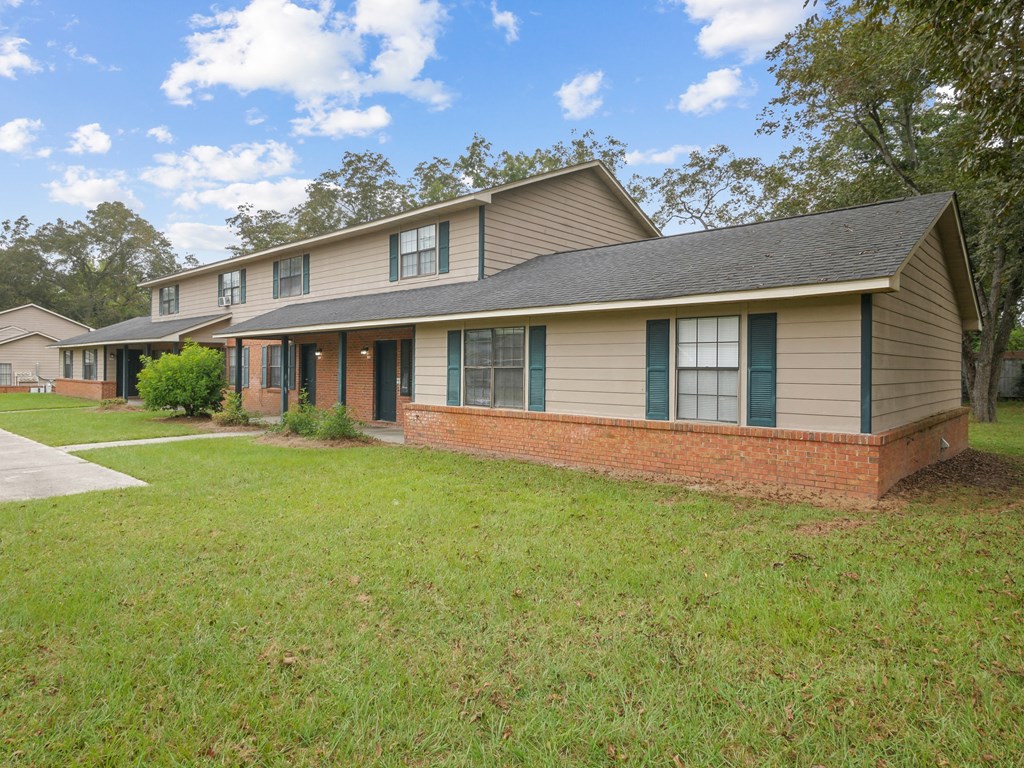 the front of a house with a lawn and a sidewalk