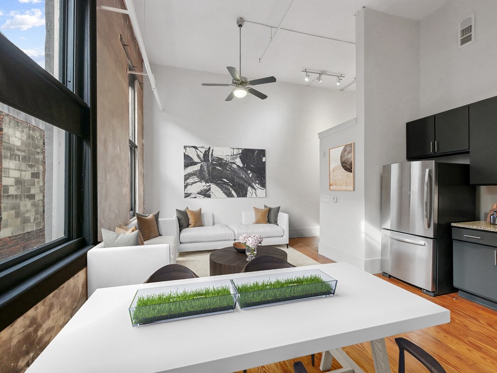 a kitchen and living room with a white table and a large window