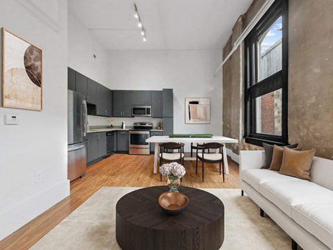 a living room with a couch and a table and a kitchen