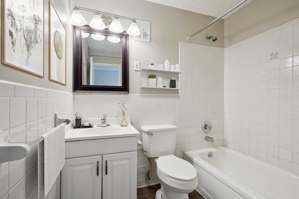 a white bathroom with a tub and a sink and a toilet