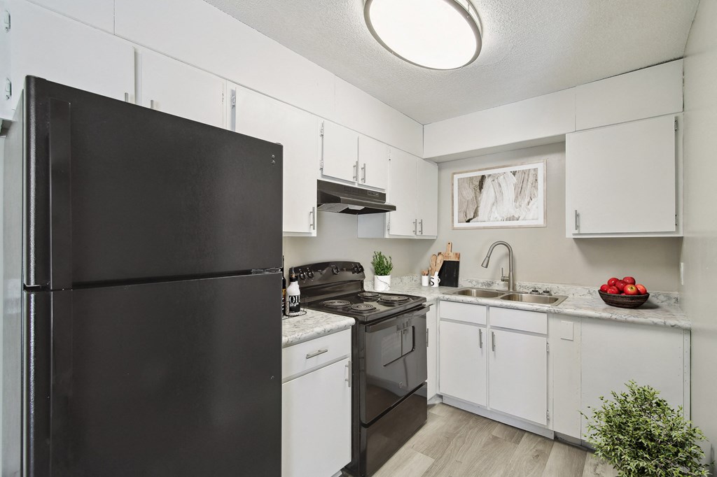 a kitchen with white cabinets and black appliances and a black refrigerator