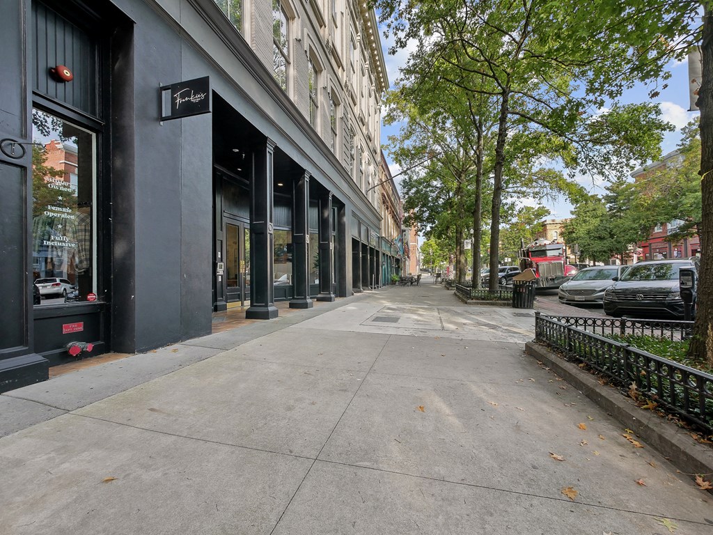 a city street with buildings and trees and a sidewalk