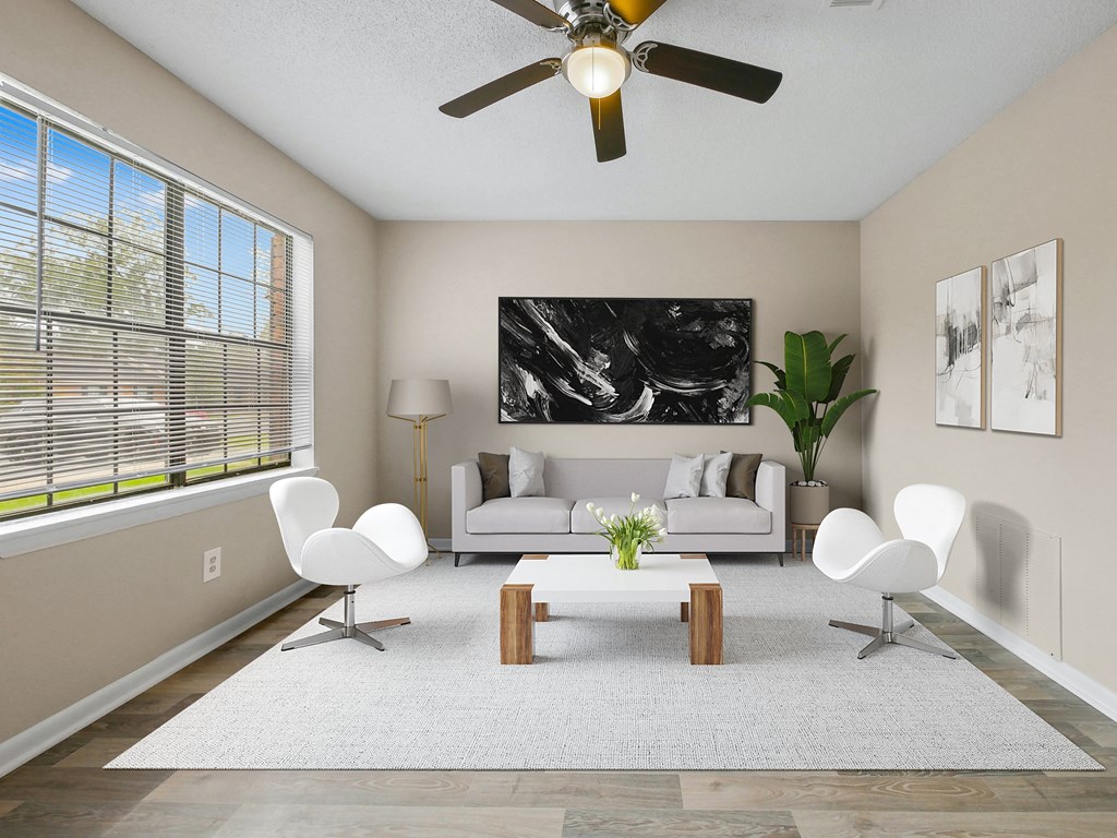 a living room with white furniture and a ceiling fan
