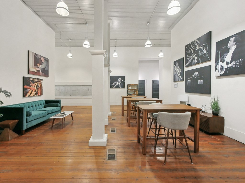 a dining room with tables and chairs and a living room with a green couch