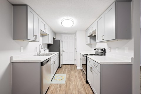 A kitchen with white cabinets and a white counter top.