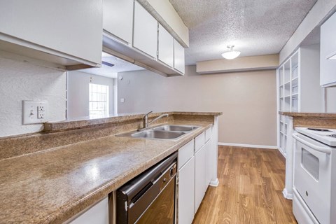 A kitchen with white cabinets and a brown countertop.
