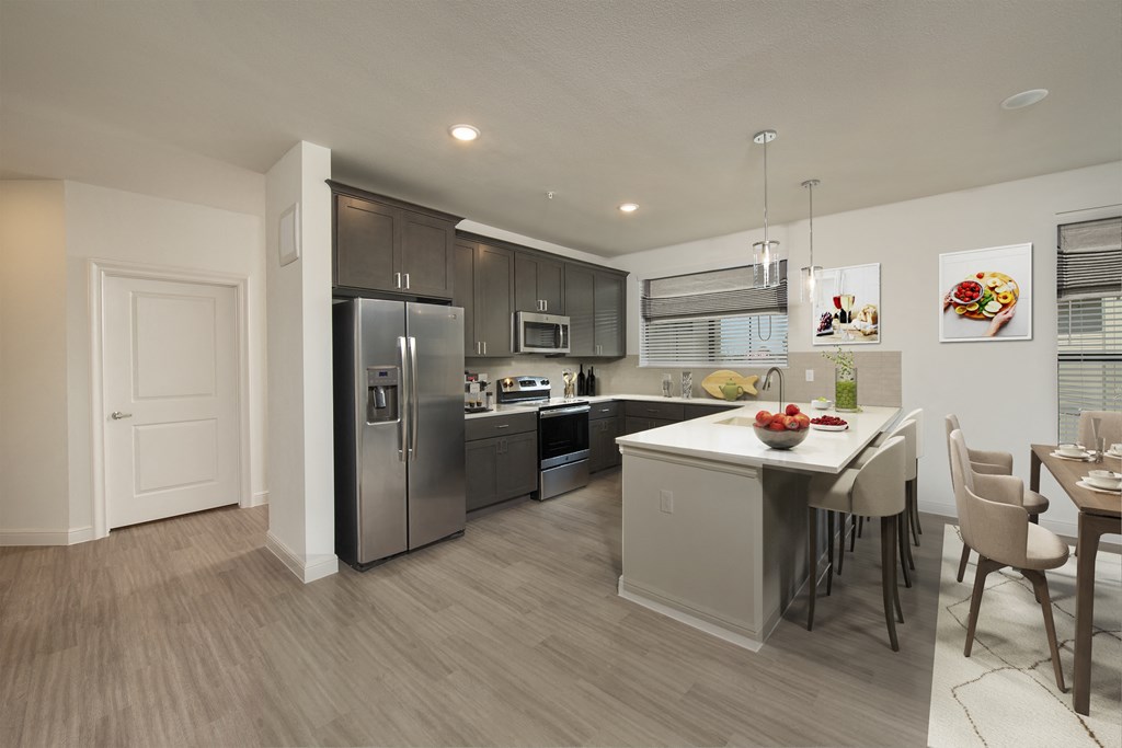 a kitchen and dining room with stainless steel appliances and a table with chairs