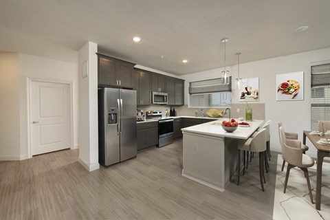 a kitchen and dining room with stainless steel appliances and a table with chairs
