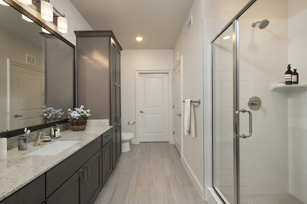 a bathroom with a shower and a sink and a mirror