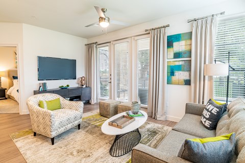 a living room with a couch and a chair and a television