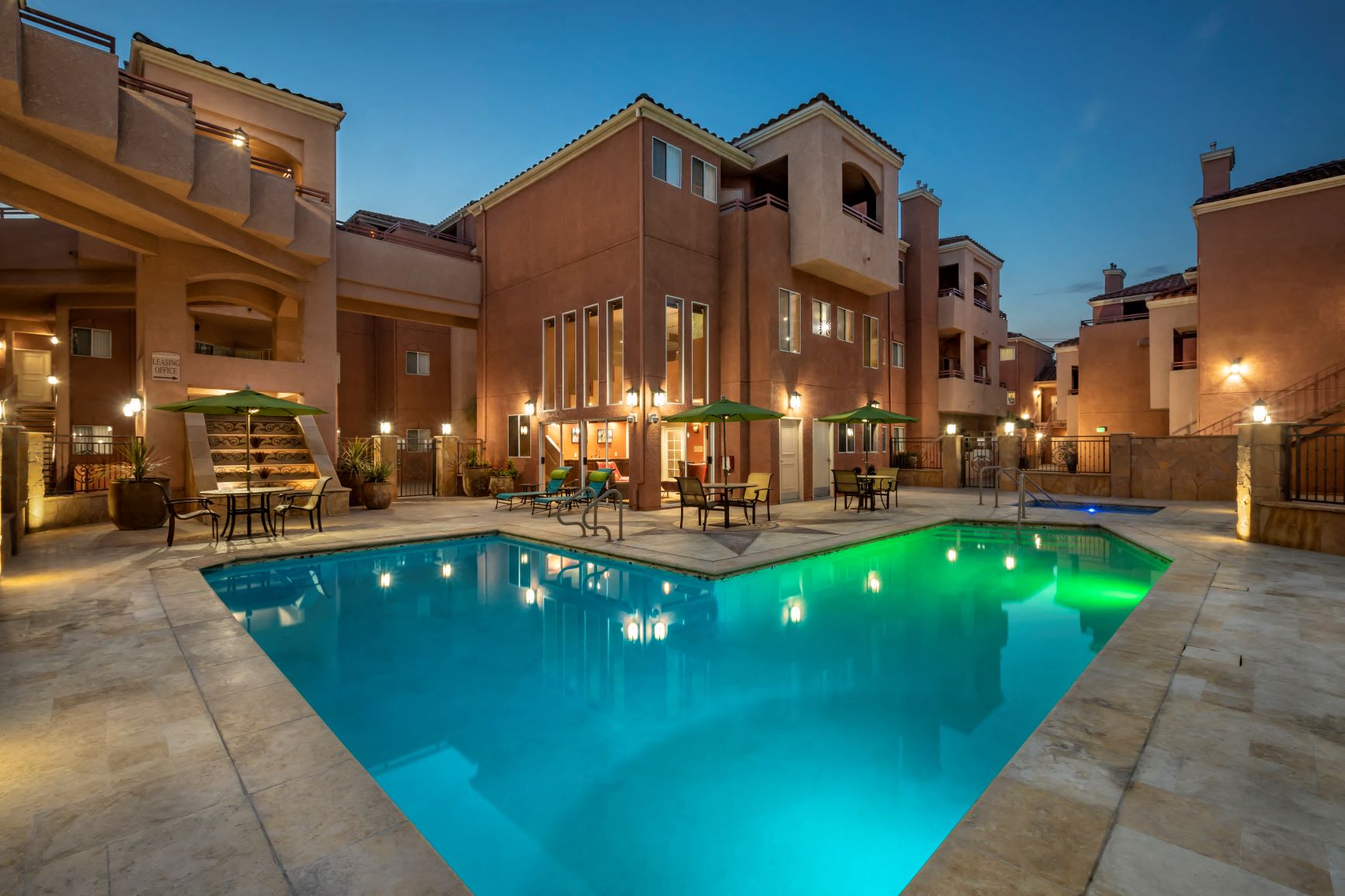 Apartments in Burbank, CA -  View of Lit Up Pool and Patio  Tables and Surrounding Buildings