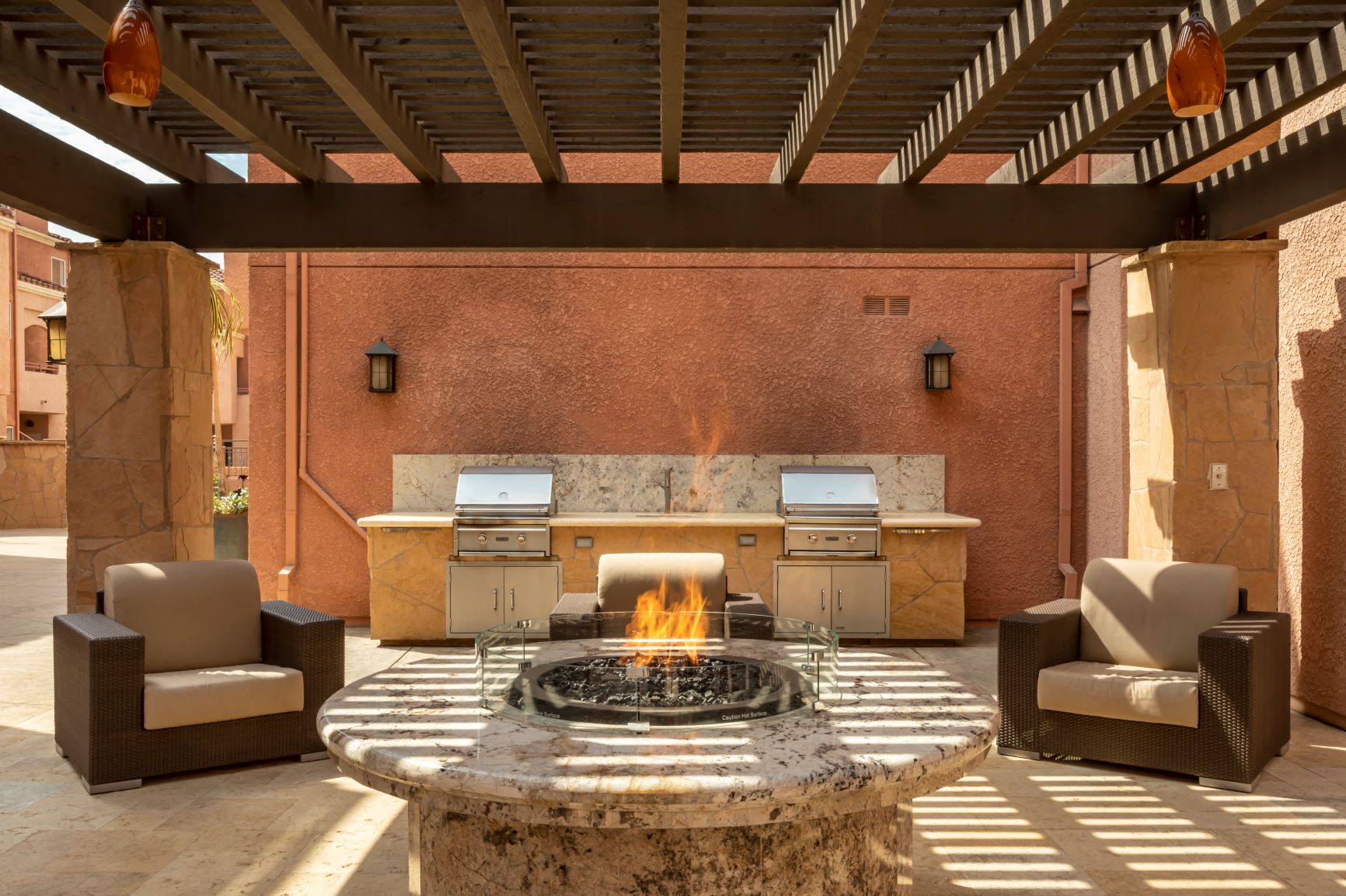Apartments in Burbank, CA - Outdoor Grilling Area with Pergola and Lit Fire Pit and Seating scott villa