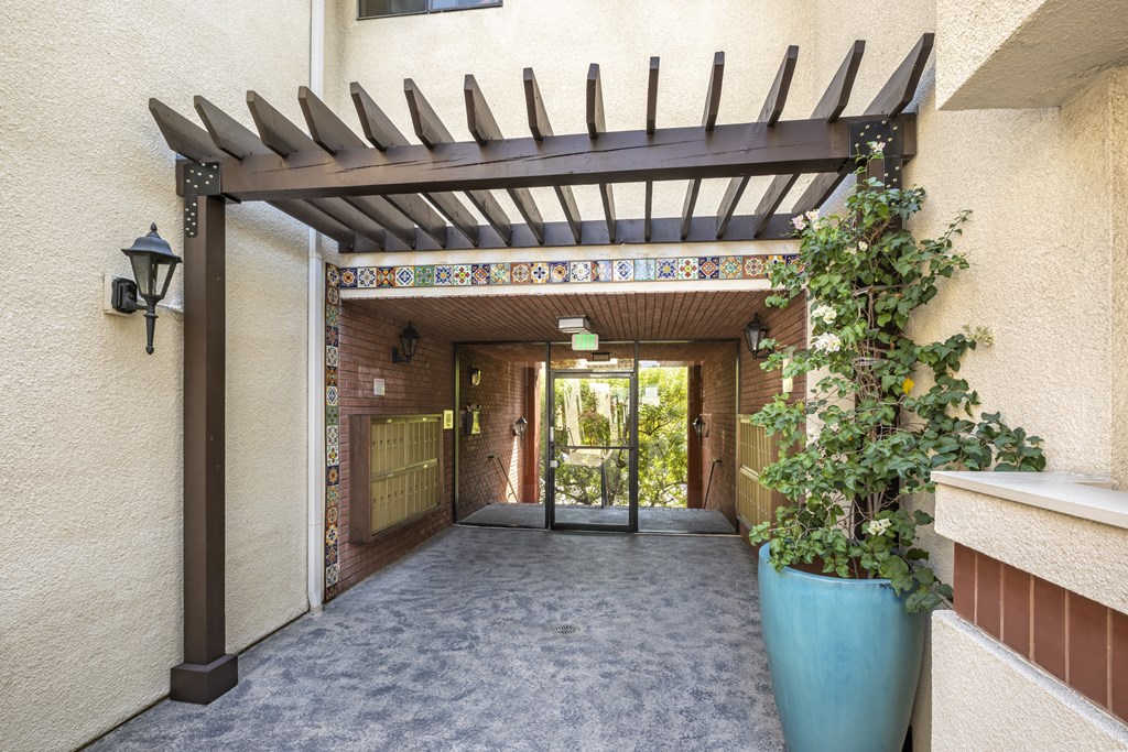 Apartments in Encino, CA - Exterior Walkway with Pergola and Covered Mailbox Area