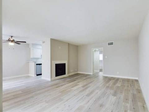 A spacious living room with a fireplace and wood flooring.