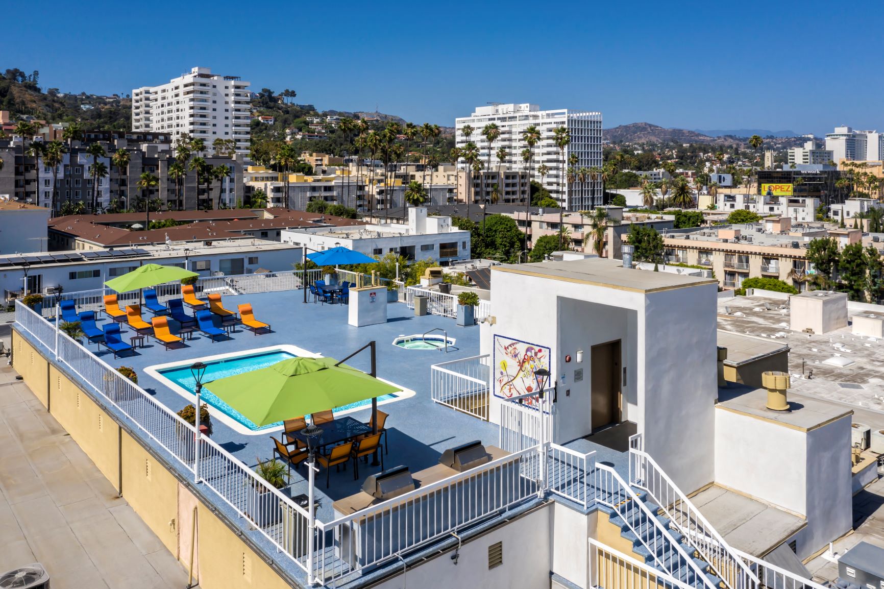 Apartments in Hollywood, CA - Aerial of Rooftop Pool, Jacuzzi, Patio Area with Lounge Chairs, Tables and Umbrellas, Grilling Area and Surrounding Areas Sutton
