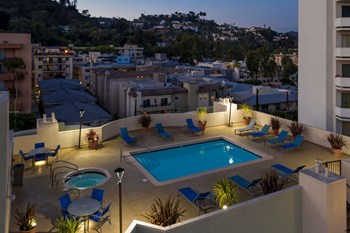 Apartments in Hollywood, CA - Elevated Night Time View of Pool, Jacuzzi, Patio with Lounge Chairs and Tables with view of  Surrounding Areas summit. - Photo Gallery 8