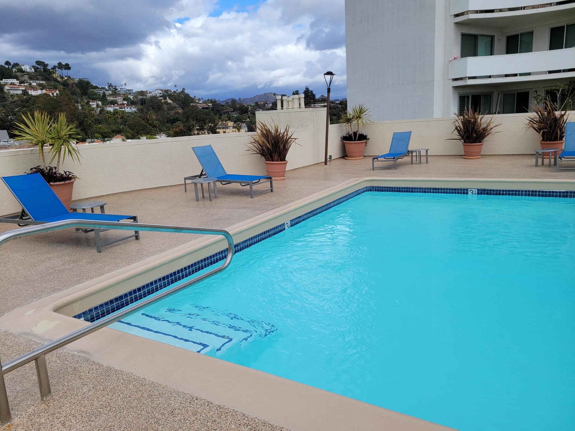Apartments in Hollywood, CA - Pool, Patio with Lounge Chairs and Tables with view of Mountain side