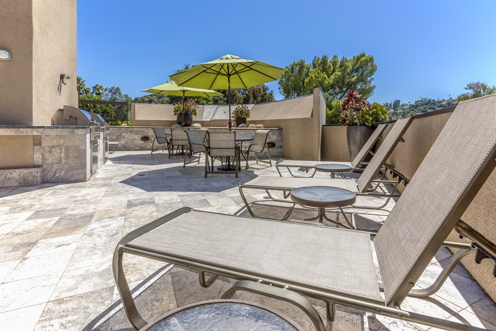 Apartments in Sherman Oaks, CA - Outdoor Grilling Area with Tables and Lounge Chairs