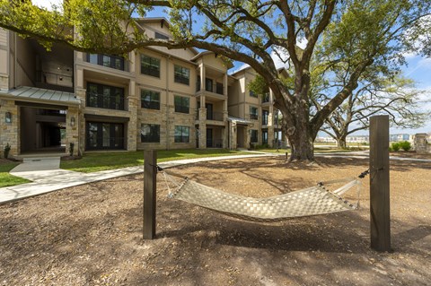 a hammock sitting in front of an apartment building