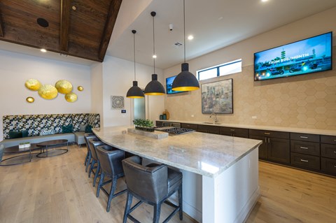 a kitchen with a large island and a dining area with chairs
