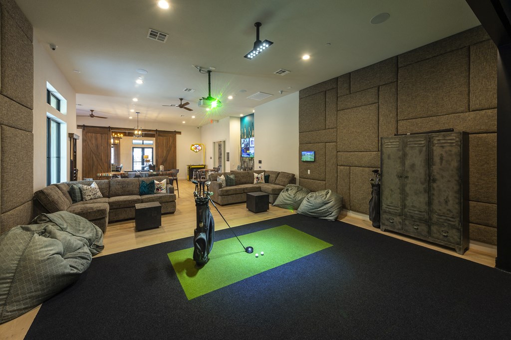 a workout room with a golf ball in the middle of a green rug