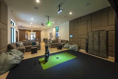 a workout room with a golf ball in the middle of a green rug