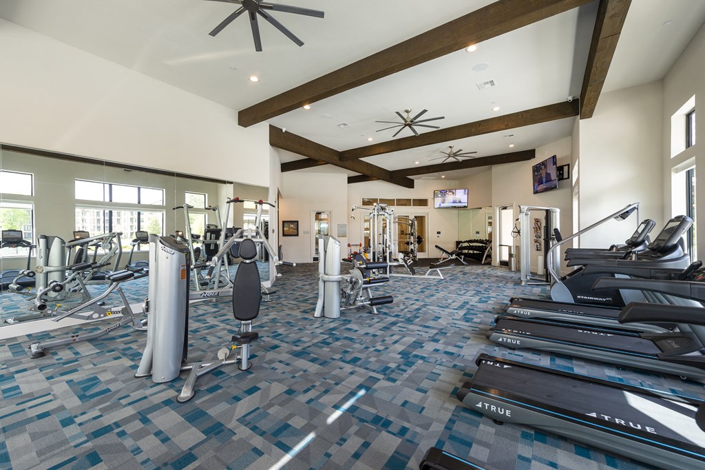 a gym with treadmills and weights in the lobby of a building