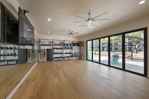 a fitness room with a large screen tv and sliding glass doors