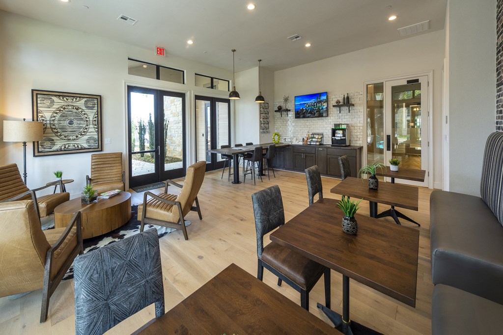 a living room and dining room area with tables and chairs and a kitchen