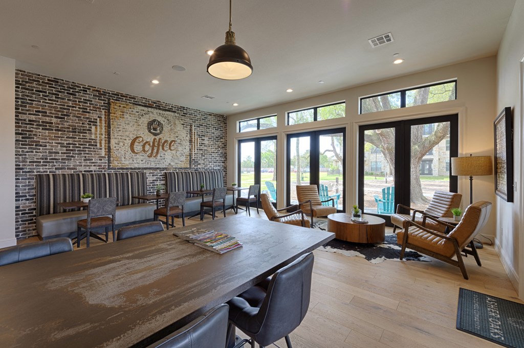 the lobby of a coffee shop with a large table and chairs