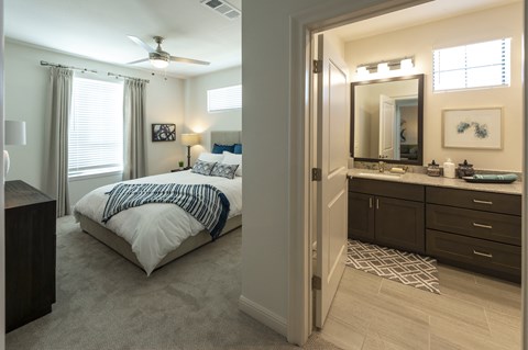 a bedroom with a bed and a vanity with a mirror