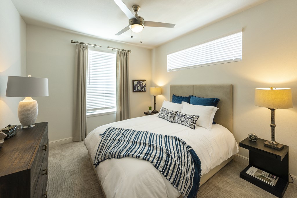 a bedroom with a large bed and a ceiling fan