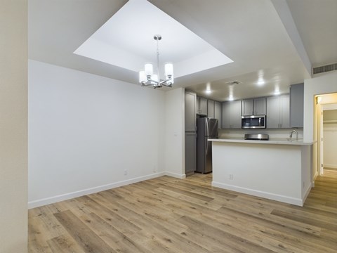 A kitchen with a white counter and a refrigerator.