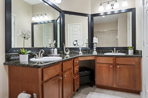 A bathroom with a vanity, sink, and mirror.