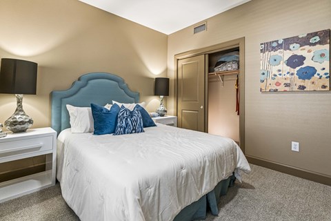 A bedroom with a bed, nightstand, and lamp.