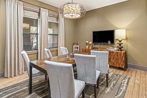 Conference room with a wooden table and grey chairs.