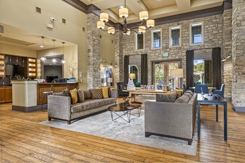 A living room with a grey couch and a wooden floor.