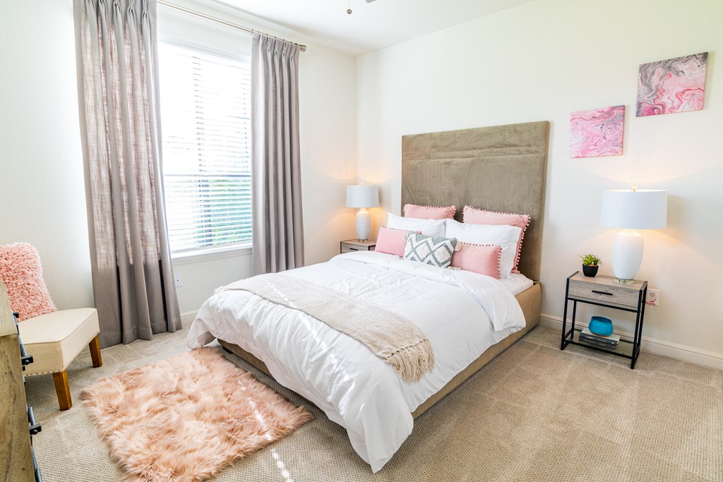 a bedroom with a bed and a chair and a window