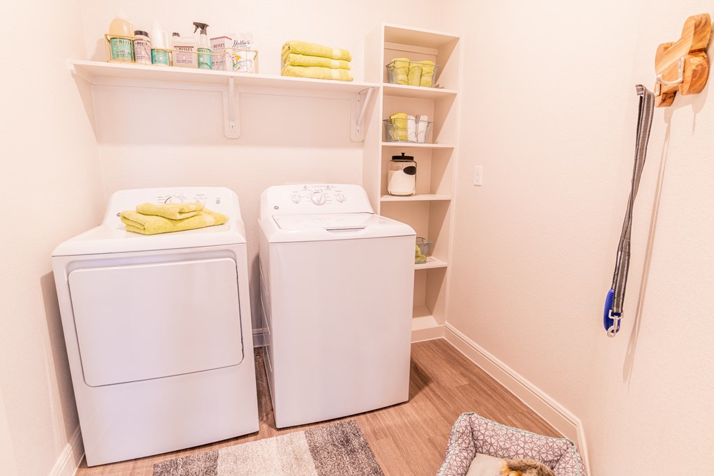 a washer and dryer in a laundry room with shelves