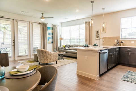 an open kitchen and living room with a table and chairs