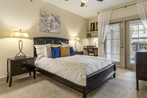 A bedroom with a large bed and a ceiling fan.