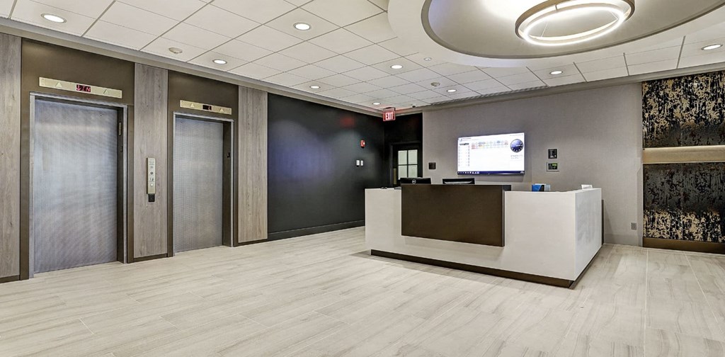 a large lobby with two elevators and a reception desk at The Ivanhoe Apartments, Hackensack, 07601