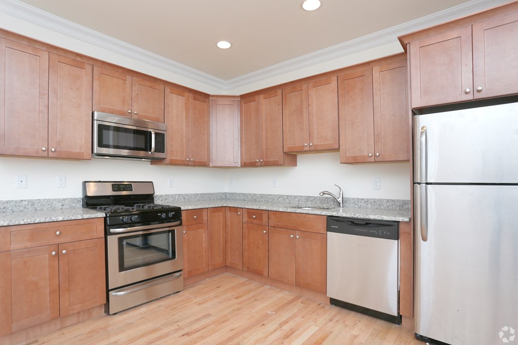 a kitchen with wooden cabinets and stainless steel appliances at Greenway Village Apartments, New Jersey