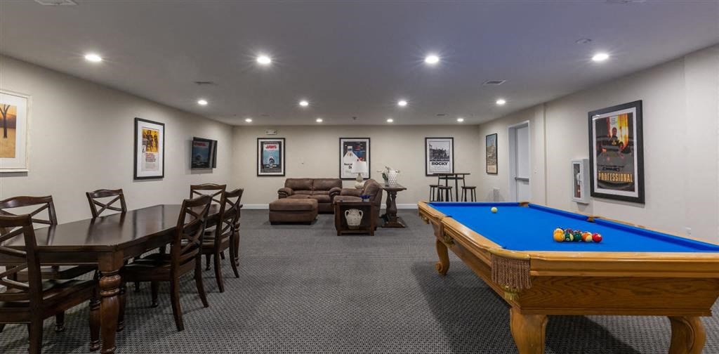 a game room with a pool table and chairs at Zephyr Ridge Apartment Homes, Cedar Grove, New Jersey