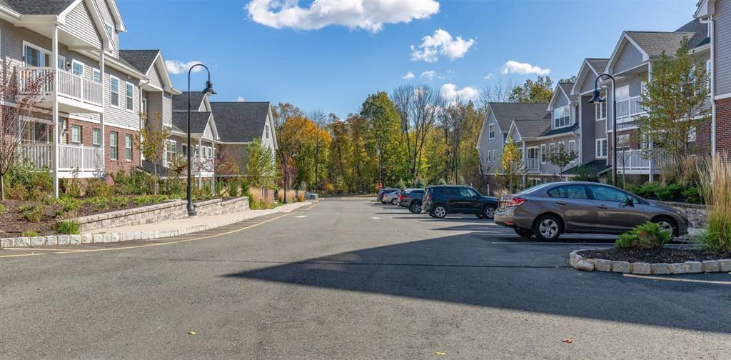 a street view of a row of houses with cars parked on the side of the road at Zephyr Ridge Apartment Homes, Cedar Grove, 07009