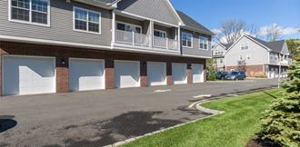 a row of houses with white garage doors