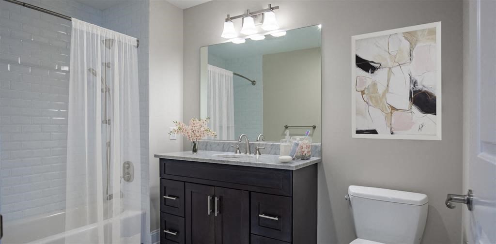 a bathroom with a toilet sink and mirror at Zephyr Ridge Apartment Homes, Cedar Grove, NJ