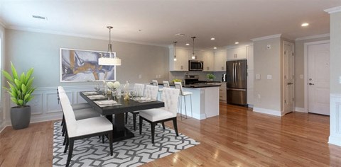 a dining room with a table and chairs and a kitchen in the background at Zephyr Ridge Apartment Homes, New Jersey
